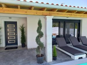 a patio with chairs and a wooden pergola at Diamond Luxury Villa Corfu 5 Bedroom Luxury Villa in Mesongi