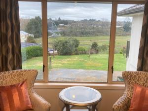 a room with a window with a table and chairs at Cambridge Te Awa Rivertrail BnB in Cambridge