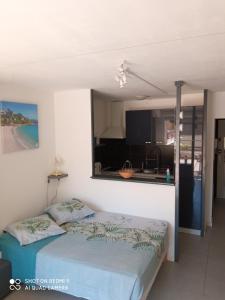 1 dormitorio con cama y vistas a la cocina en Residence Saint Clair - Studio Elena, en Cap d'Agde