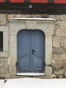 een blauwe deur in een stenen gebouw met sneeuw bij Ferienwohnung Kieslich in Habrachćicy