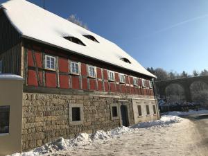 a building with snow on top of it at Ferienwohnung Kieslich in Habrachćicy