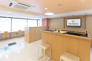 ein Büro mit einer Bar und einem TV an der Wand in der Unterkunft The OneFive Osaka Sakaisuji in Osaka