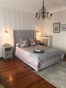 um quarto com uma cama e um lustre em La Casa Verde B&B em Trivero