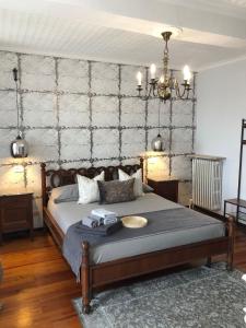 a bedroom with a bed and a chandelier at La Casa Verde B&B in Trivero