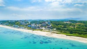 an aerial view of a beach with buildings and the ocean at Pension Badawa in Gangneung