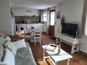 sala de estar con sofá, TV y mesa en Halte Nature en Baie de Somme, en Saint-Valery-sur-Somme