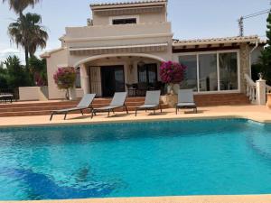 a house with a swimming pool in front of a house at THE BEST HOLIDAY VILLA in Calpe