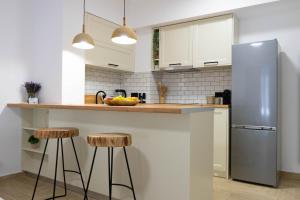 Marilias Luxury Studio Apartment في كيساموس: مطبخ مع كونتر مع الكراسي وثلاجة
