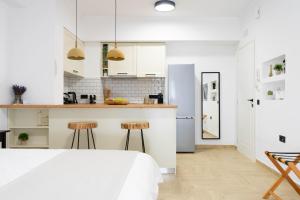 a white kitchen with a bed and two stools at Marilias Luxury Studio Apartment in Kissamos