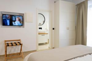 Marilias Luxury Studio Apartment في كيساموس: غرفة نوم مع سرير وتلفزيون على الحائط