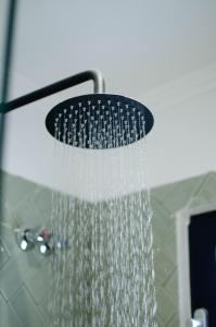 a shower head with water coming out of it at Marilias Luxury Studio Apartment in Kissamos