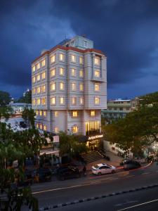 - un grand bâtiment blanc avec des fenêtres donnant sur une rue de la ville dans l'établissement Ariya Nivaas A Vegetarian Hotel, à Trivandrum