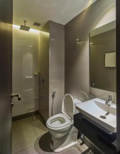 a bathroom with a toilet and a sink at Ariya Nivaas A Vegetarian Hotel in Trivandrum