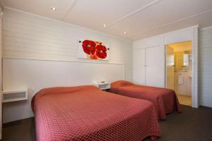 two beds in a room with red sheets on them at Econo Lodge Portland in Portland