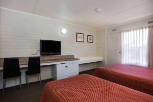 a hotel room with two beds and a flat screen tv at Econo Lodge Portland in Portland