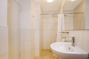 Un baño blanco con lavabo y ducha. en Econo Lodge Portland, en Portland 11 fotos más