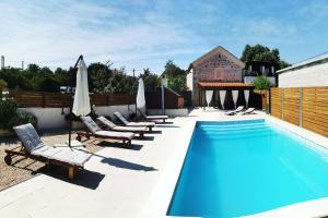 a pool with chaise lounge chairs and a swimming pool at Apartments Malic in Pridraga