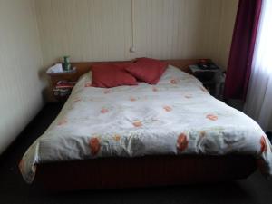 Un dormitorio con una cama con flores. en Hospedaje Teresita, en Puerto Montt