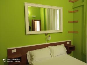 a green bedroom with a bed and a mirror at NEW PARADISE in Rome