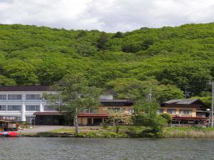 un bâtiment sur la rive d'un lac à côté d'une montagne dans l'établissement Kimimachisou, à Chino