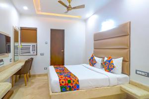 a bedroom with a bed and a desk and a television at FabHotel Ruklo in Patna