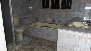 a bathroom with a tub and a toilet and a sink at Warmbaths Thai Spa and Guest House in Bela-Bela