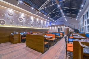 a restaurant with tables and chairs and plates on the wall at Hotel Park Tree, Kolhapur in Kolhapur