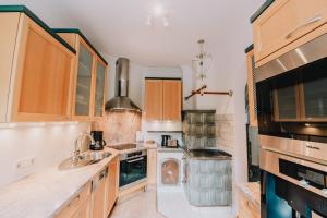 a kitchen with wooden cabinets and a sink and a stove at Townville Chalet´s in Flachau