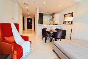 uma sala de estar com uma cadeira vermelha e uma mesa em Marco Polo - Serene 1 BR APT amidst Golf Course with Gym & Pool em Dubai