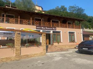 ein Gebäude mit einem davor geparkt in der Unterkunft MOTEL Restaurant NICOL ARMENIS in Armeniş