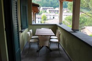 een tafel en stoelen op een balkon met een raam bij Residence Elettra in Crone