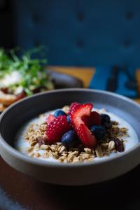 a bowl of granola with strawberries and blueberries at The Tal-Y-Cafn Hotel in Tal-y-Cafn