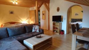 a living room with a couch and a bed at Hanneshof in Riedlhütte