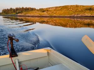 a boat on a body of water with a bird in the water at Vollvaagen Apartments Smøla, boat included in Smøla