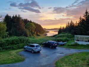 two cars parked in a parking lot next to a river at Vollvaagen Apartments Smøla, boat included in Smøla