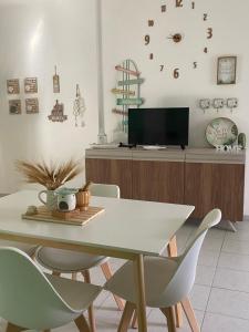 a dining room with a table and chairs and a tv at Apulia Home in Zapponeta