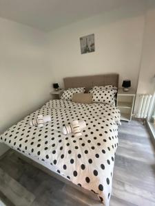 a bedroom with a large bed with black and white polka dots at Apartman OMAR stan na dan besplatan parking Sarajevo in Sarajevo