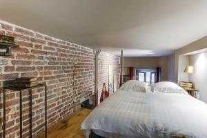 a bedroom with a brick wall and a bed at Bail Mobilité Appartement, Place Vendome, Opera in Paris