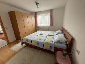 een kleine slaapkamer met een bed en een raam bij Ferienwohnung - Haus Waibel in Überlingen