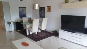 a living room with a dining table and a television at Golfo d'Oro in Ascona