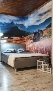 a bedroom with a large painting on the wall at Pod Śnieżynką in Zakopane