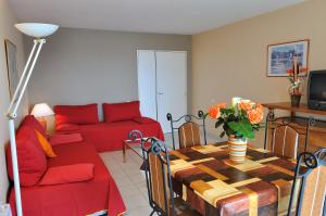 カンヌにあるレジドホテル ヴィラ モーパッサンのリビングルーム(赤いソファ、テーブル付)