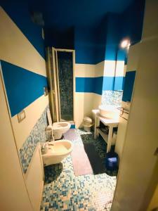 uma casa de banho azul e branca com 2 WC e um lavatório em Al Castello em Catânia