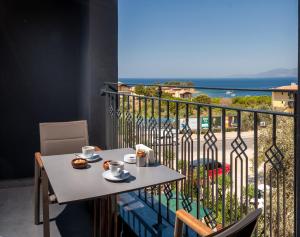 een balkon met een tafel en uitzicht op de oceaan bij TNR Otel & Spa in Kuşadası