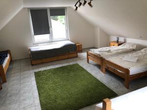 sypialnia na poddaszu z 2 łóżkami i oknem w obiekcie Ubytování na Čechách w mieście Děčín