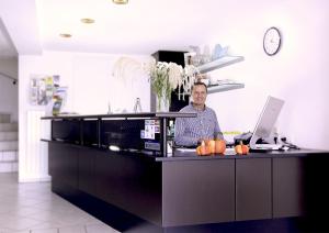 a man standing behind a counter in a kitchen at Lupinenhotel Bodensee - Apartment mit Seeblick in Sipplingen