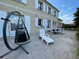 eine Schaukel und ein Stuhl vor einem Gebäude in der Unterkunft Chambre d'hôte in Fay-les-Étangs