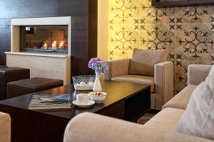 a living room with a table and chairs and a fireplace at Theta Hotel Pelion in Agios Dimitrios +41 photos