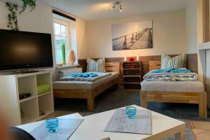 a living room with two couches and a flat screen tv at Ferienwohnung Schmidt in Rosengarten