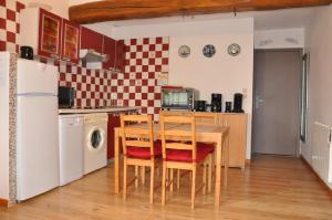 a kitchen with a table and chairs and a refrigerator at Gite Ty-Coz in Charly-sur-Marne